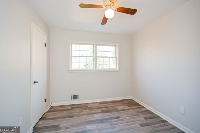 empty room with ceiling fan and dark hardwood / wood-style flooring