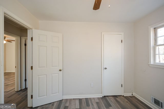 unfurnished bedroom featuring dark hardwood / wood-style floors and ceiling fan