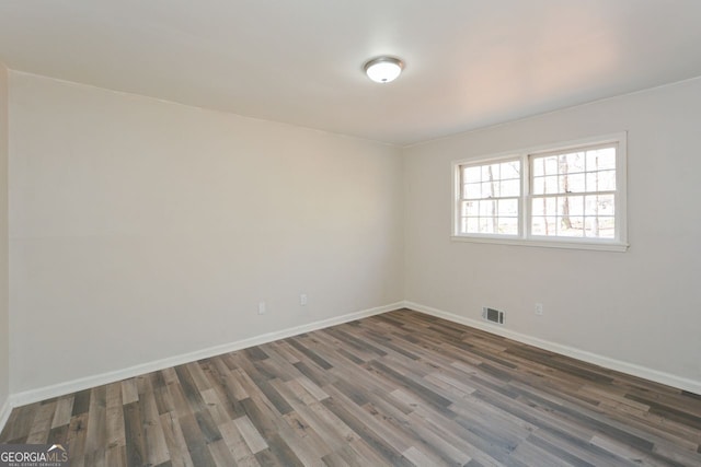 unfurnished room with dark hardwood / wood-style flooring