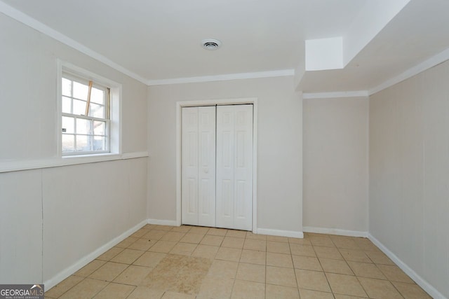 unfurnished bedroom featuring ornamental molding, light tile patterned floors, and a closet