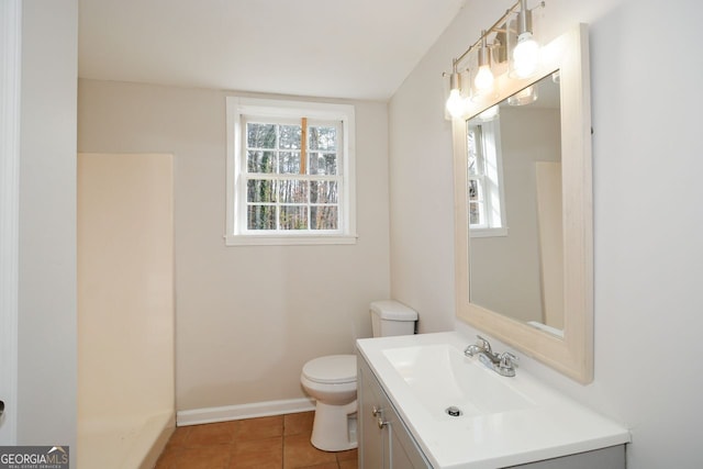 bathroom with tile patterned flooring, vanity, a wealth of natural light, and toilet