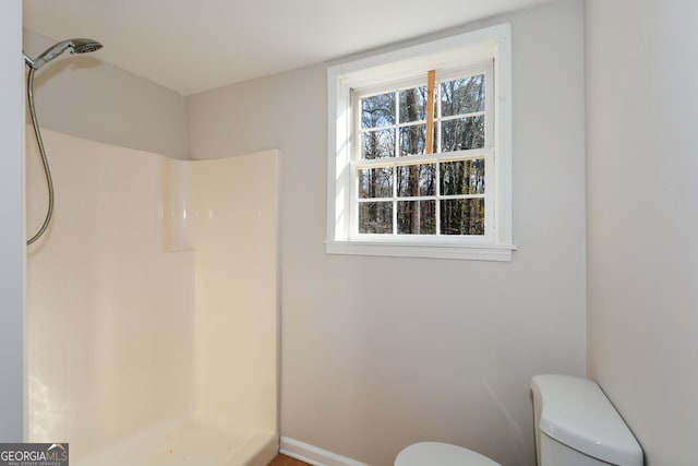 bathroom with plenty of natural light, toilet, and walk in shower