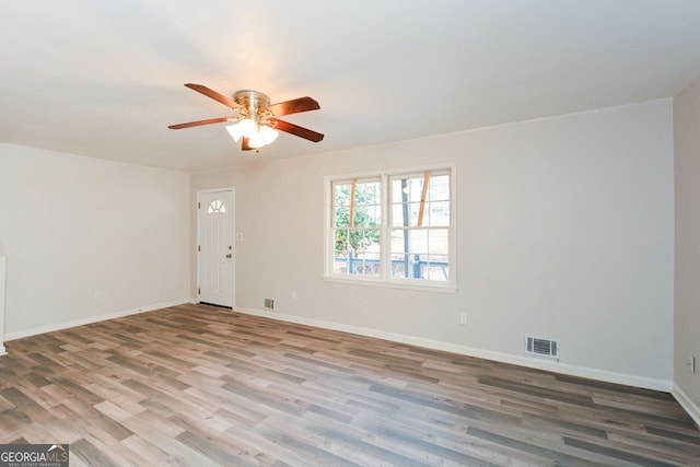 empty room with hardwood / wood-style floors and ceiling fan