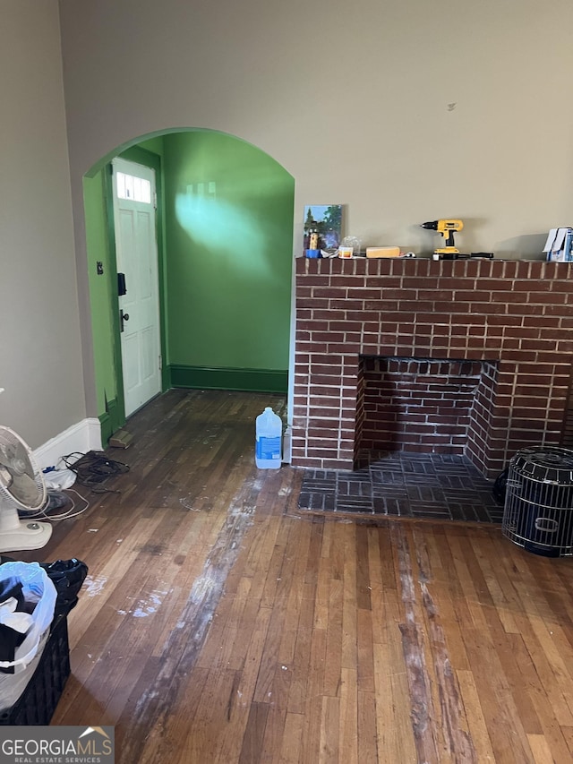 unfurnished living room with a tiled fireplace and hardwood / wood-style floors