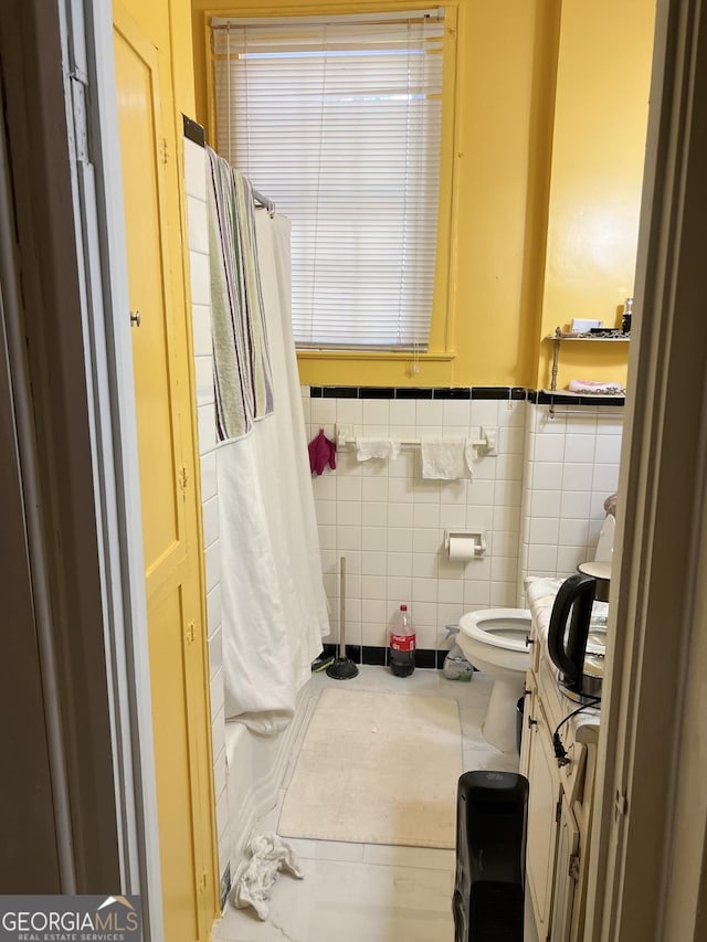 bathroom with tile walls and toilet