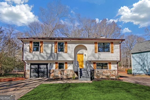 split foyer home featuring a garage and a front lawn