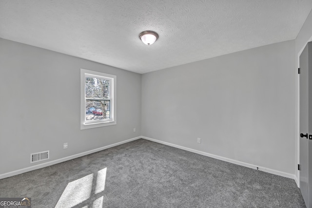 carpeted spare room featuring a textured ceiling