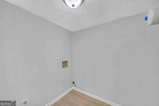 washroom with hardwood / wood-style flooring, hookup for an electric dryer, hookup for a washing machine, and a textured ceiling