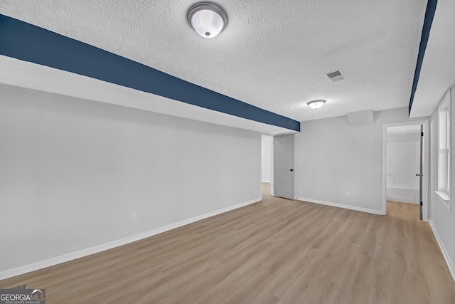 basement with a textured ceiling and light wood-type flooring