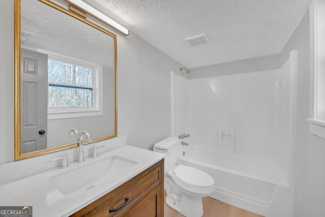 full bathroom featuring shower / washtub combination, vanity, a textured ceiling, and toilet