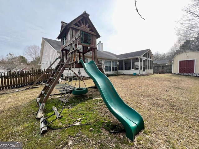 view of playground with a storage shed, a lawn, and a sunroom