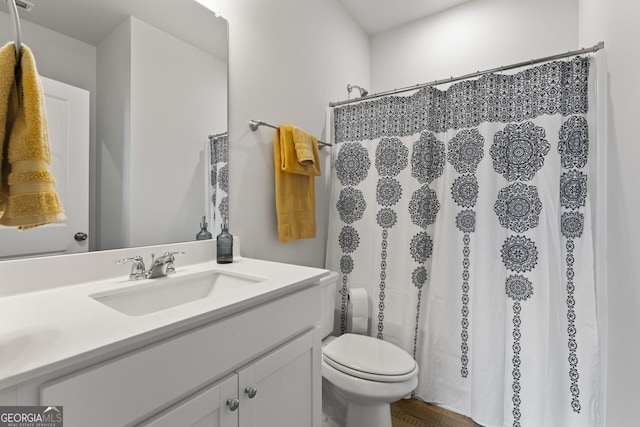 bathroom with vanity, curtained shower, and toilet