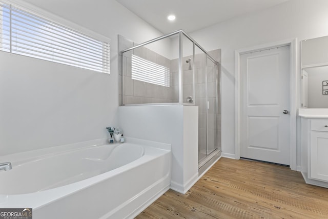 bathroom featuring vanity, hardwood / wood-style flooring, and shower with separate bathtub