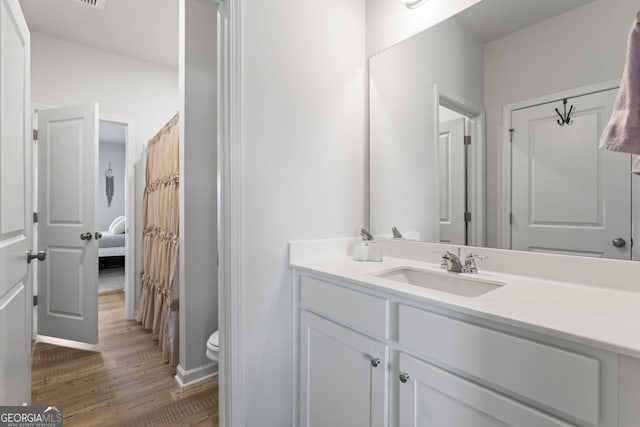 bathroom with vanity, toilet, and wood-type flooring