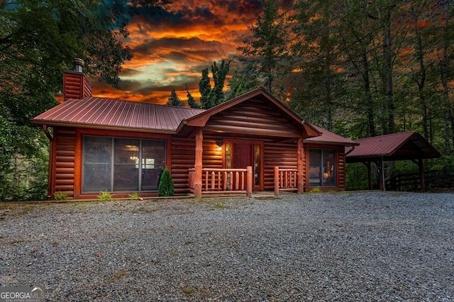 log home with a carport and covered porch