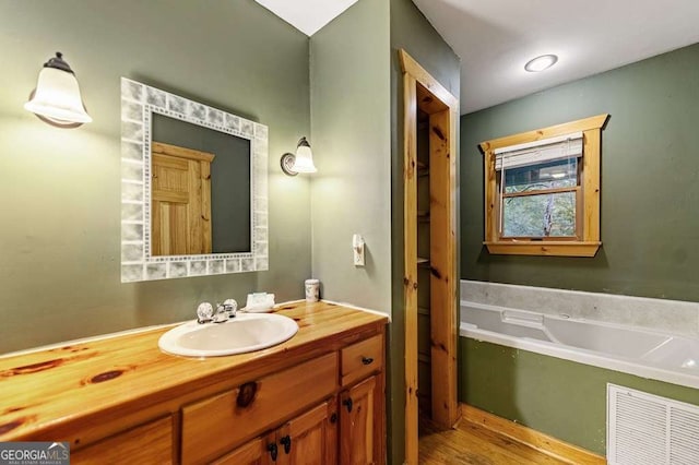 bathroom featuring vanity and a bath