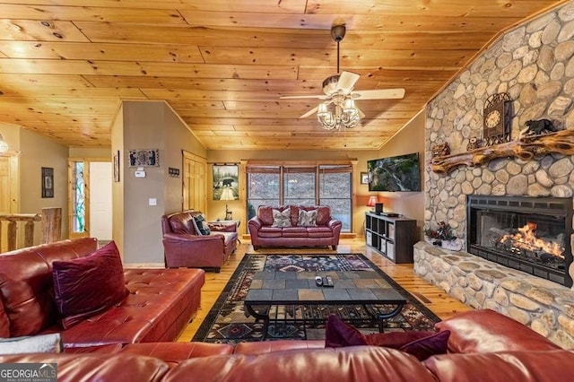 living room with lofted ceiling, a stone fireplace, light hardwood / wood-style floors, and wooden ceiling