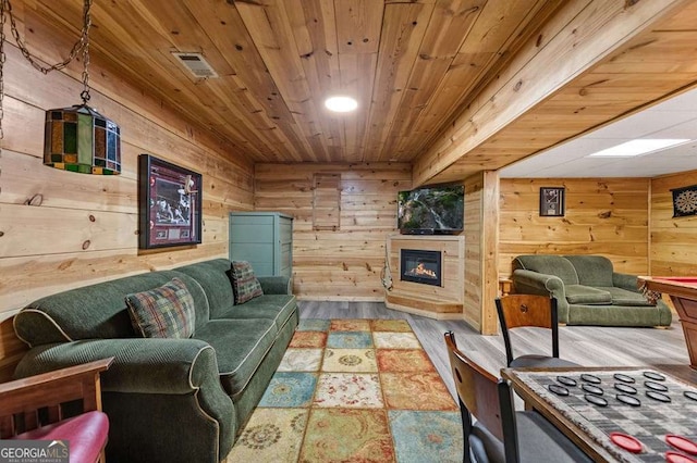 living room with hardwood / wood-style flooring, wooden ceiling, and wood walls