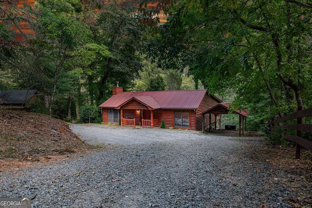 log home featuring a carport and covered porch