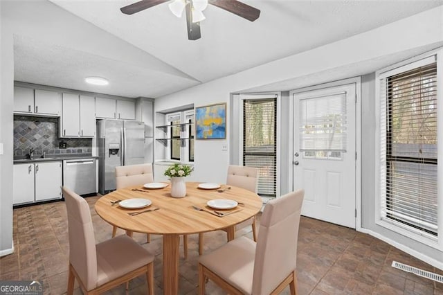 dining space featuring sink and vaulted ceiling