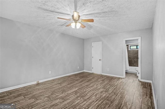 unfurnished room with ceiling fan, hardwood / wood-style floors, and a textured ceiling