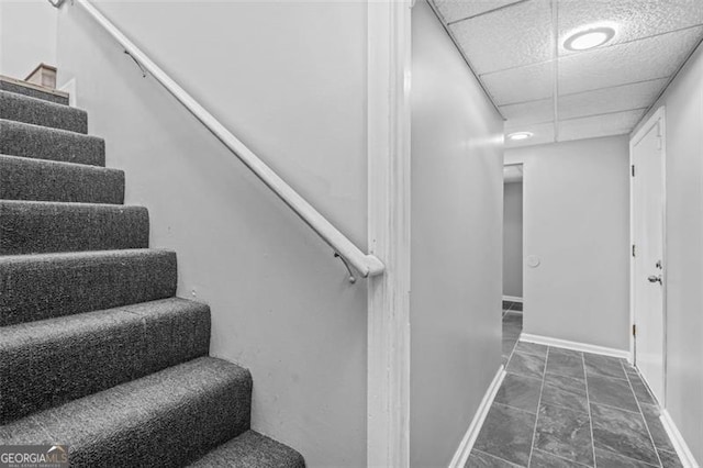 stairs featuring a paneled ceiling