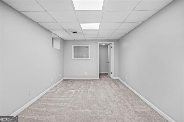 carpeted empty room featuring a paneled ceiling