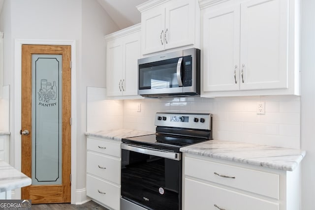 kitchen with light stone countertops, white cabinetry, appliances with stainless steel finishes, and decorative backsplash