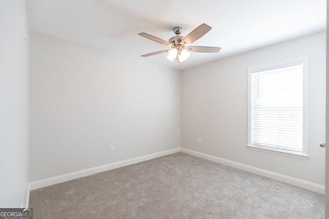 carpeted spare room featuring ceiling fan