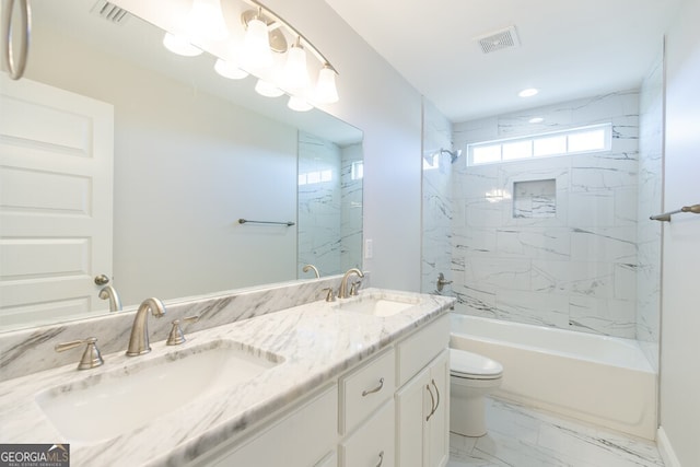 full bathroom featuring tiled shower / bath combo, vanity, and toilet