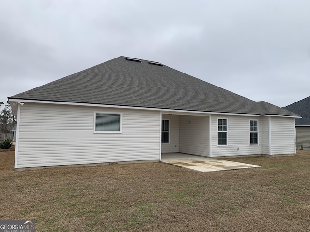 rear view of property with a lawn and a patio area