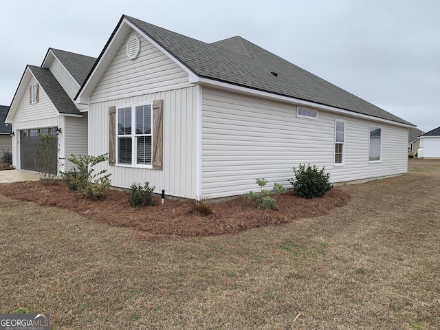 view of side of property with a garage and a yard