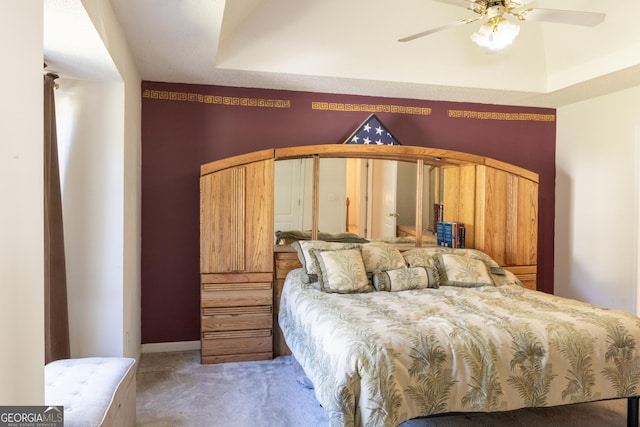 bedroom featuring a raised ceiling and carpet floors