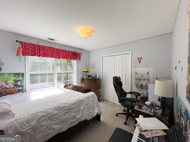 carpeted bedroom with a closet and a textured ceiling