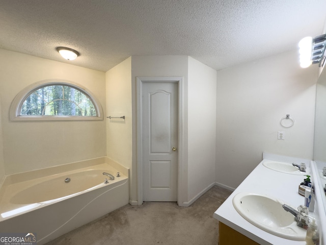 bathroom with vanity, a tub, and a textured ceiling