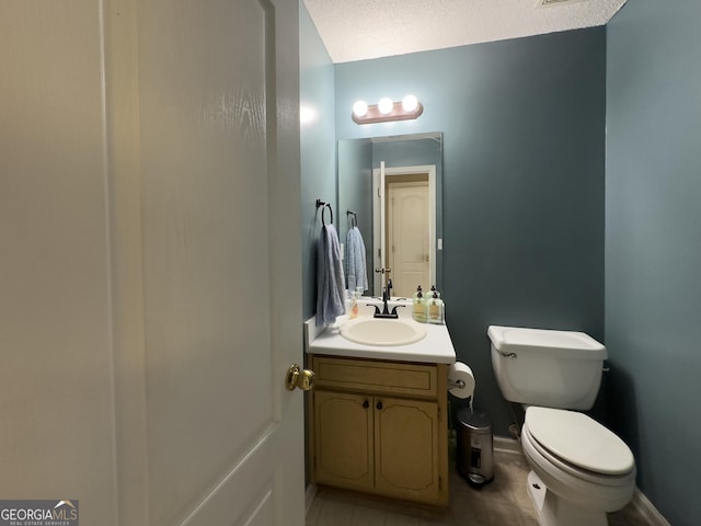 bathroom with vanity, a textured ceiling, and toilet