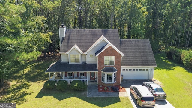 view of front facade featuring a porch, a garage, and a front lawn