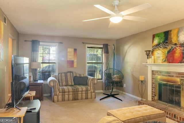 living room with ceiling fan, plenty of natural light, a fireplace, and carpet floors