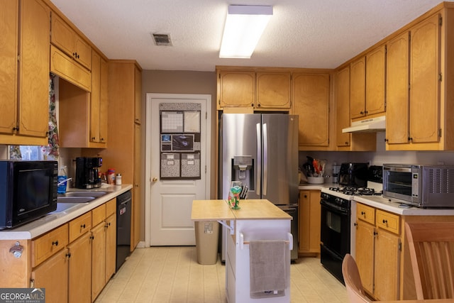 kitchen with a center island, a textured ceiling, and black appliances