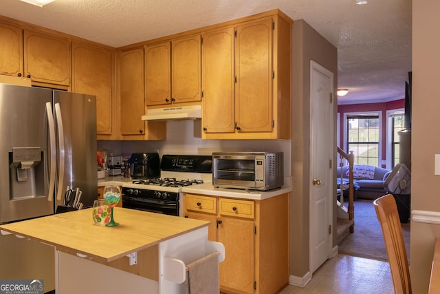 kitchen with stainless steel appliances, a center island, and a textured ceiling