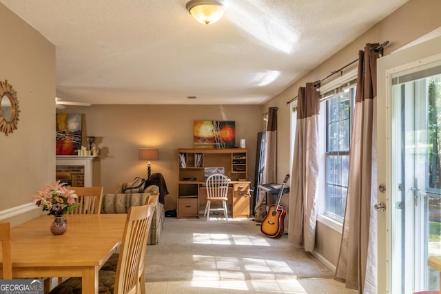 carpeted dining area featuring a brick fireplace and a textured ceiling