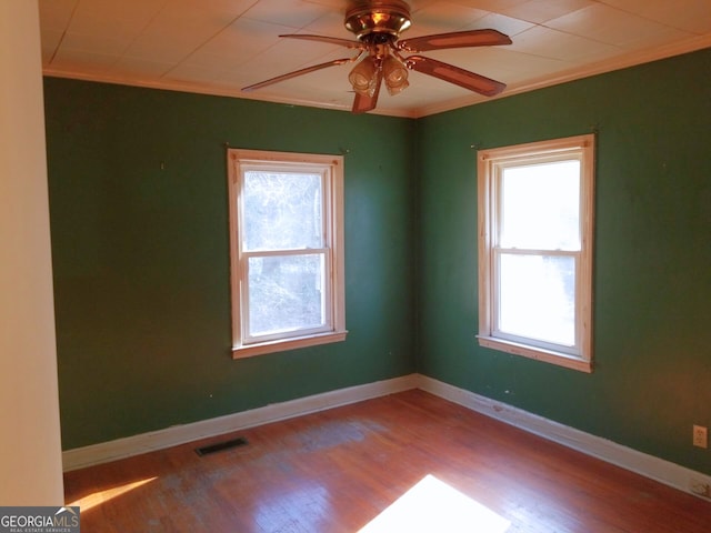 empty room with ornamental molding, light hardwood / wood-style floors, and ceiling fan