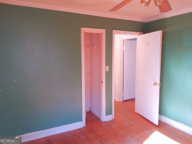 unfurnished bedroom with ceiling fan, crown molding, and light hardwood / wood-style floors