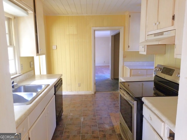 kitchen featuring sink, white cabinetry, black dishwasher, stainless steel electric stove, and wood walls