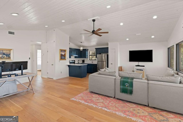 living room featuring lofted ceiling, a wealth of natural light, and light wood-type flooring