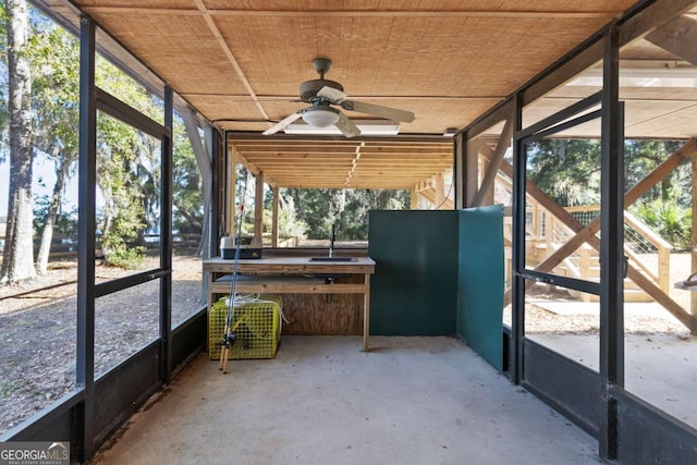 unfurnished sunroom with ceiling fan