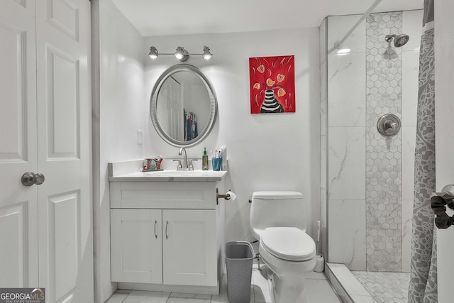 bathroom featuring tiled shower, vanity, and toilet