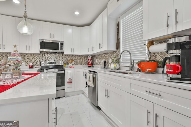 kitchen featuring white cabinetry, appliances with stainless steel finishes, sink, and pendant lighting