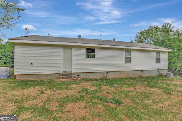 rear view of house with a yard and central AC