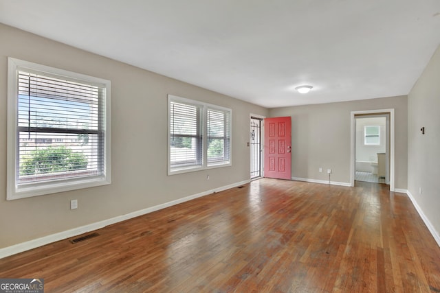 spare room featuring hardwood / wood-style flooring and plenty of natural light